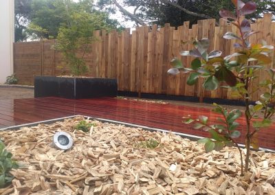 Jardinière avec copaux de bois = terrasse en parquet rouge